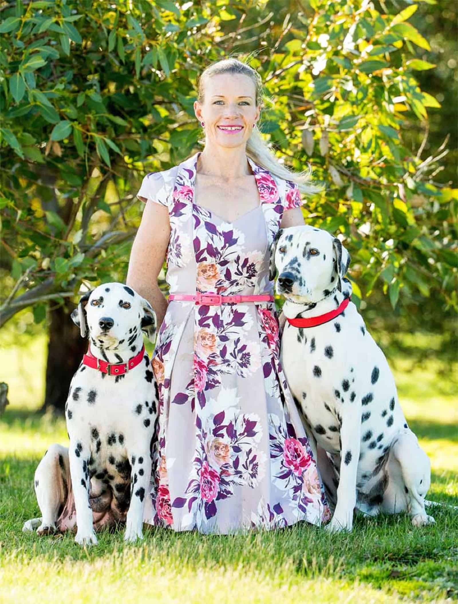 woman-with-her-two-dalmatian-dogs woman with her two dalmatian dogs in the park